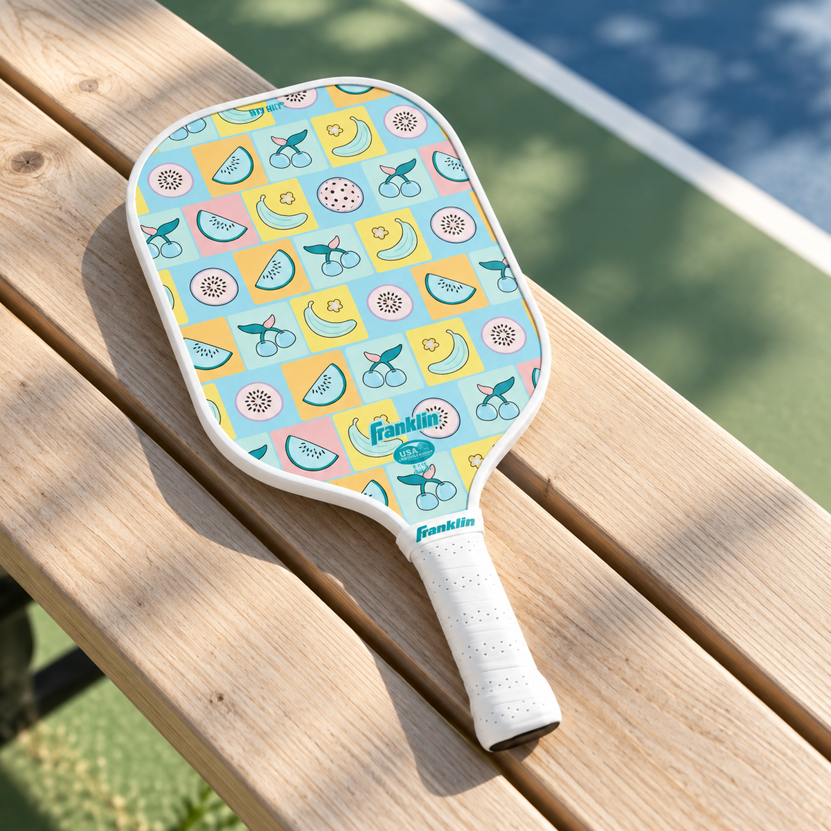 AI-generated courtside bench scene with the pastel fruit paddle and white grip.