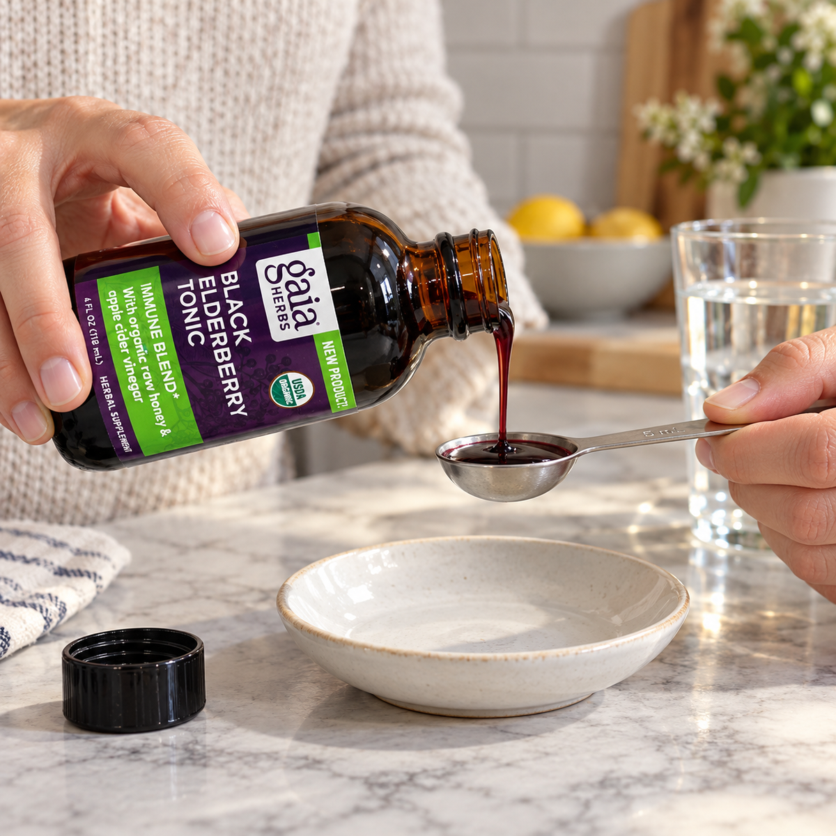 Measuring Gaia Herbs Black Elderberry Tonic into a 5 mL teaspoon