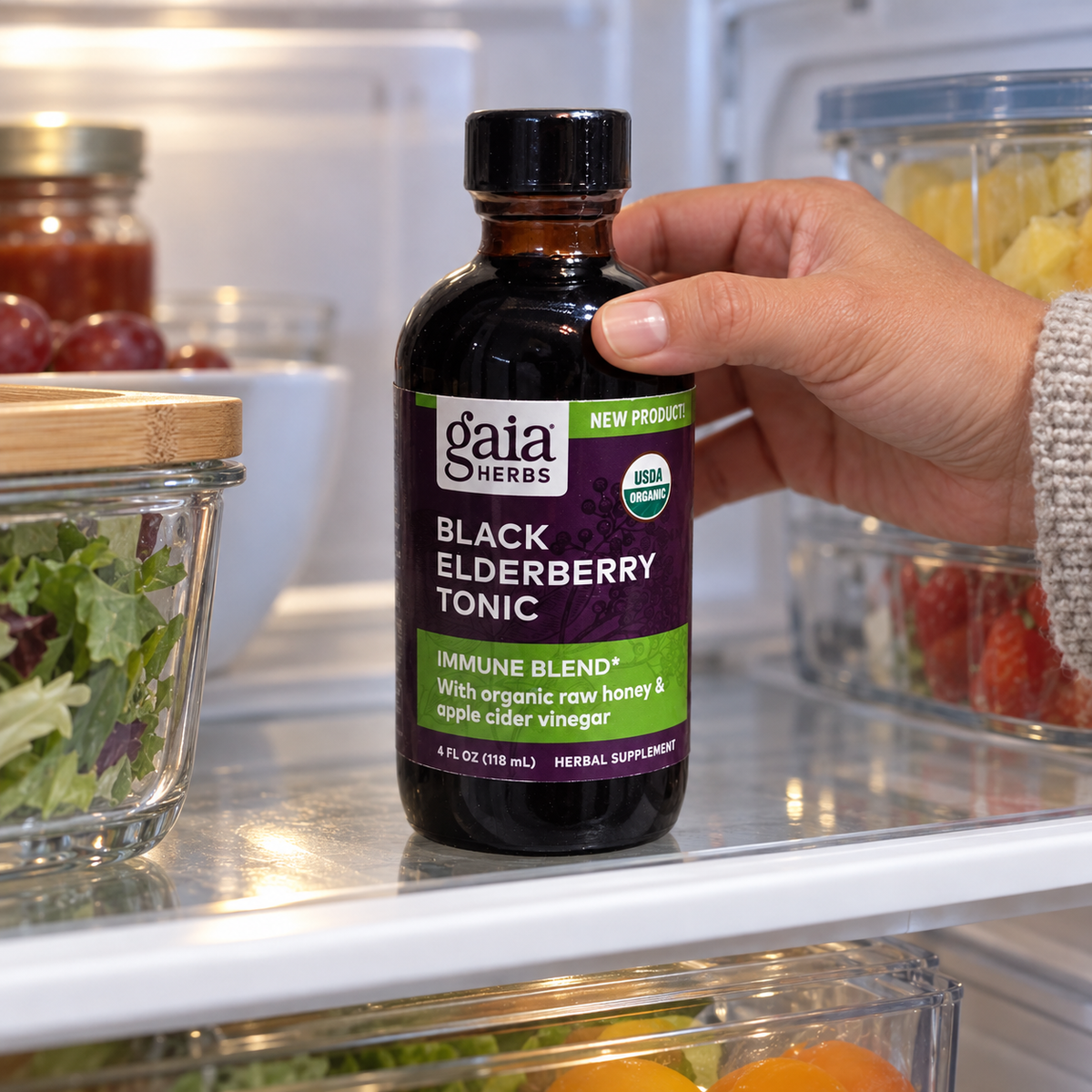 Returning the capped Gaia Black Elderberry Tonic bottle to the refrigerator