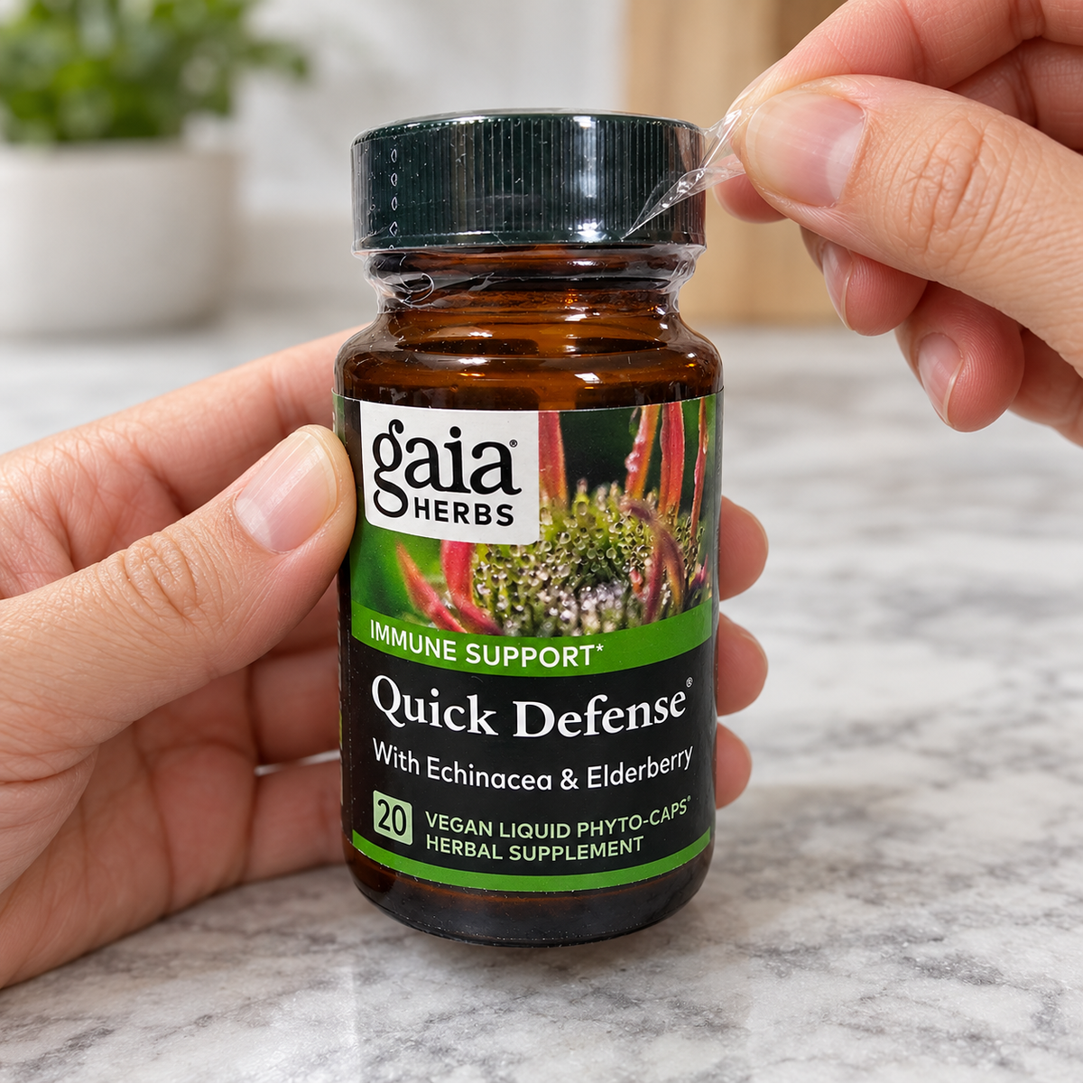 Hands removing the clear neck wrapping from a Gaia Herbs Quick Defense 20-count bottle.