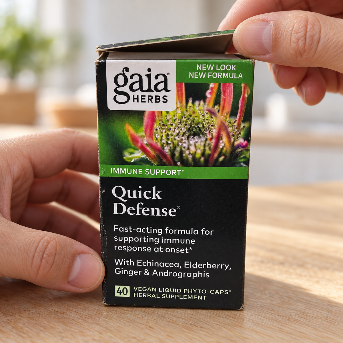 Hands opening a Gaia Herbs Quick Defense 40-count carton.