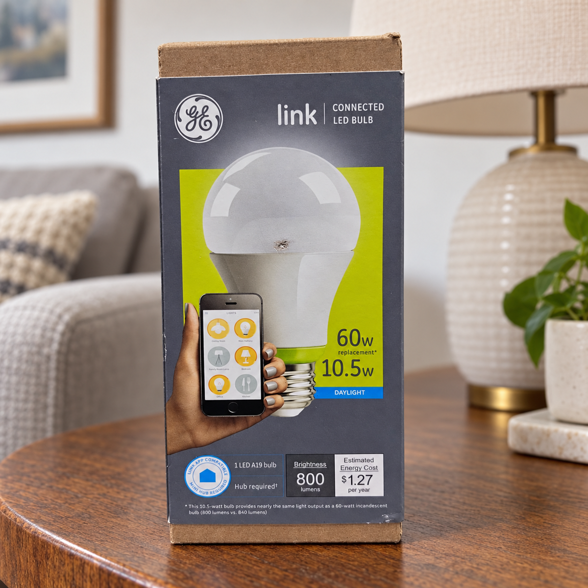 GE Link A19 daylight LED bulb carton in living room setting; AI-generated lifestyle illustration