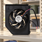 GE WR60X23363 condenser fan assembly with two cable branches and connector on a utility shelf; illustrative setting, background props not included