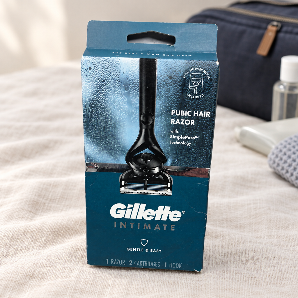 Gillette Intimate razor kit in its original blue box on cream linen beside a toiletry bag