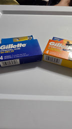 Actual blue and orange Gillette Shield 4-count retail packs showing the same UPC 047400656147; sold one pack per purchase