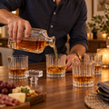 Pouring whiskey from a Godinger Ludlow decanter into one of four matching crystal glasses