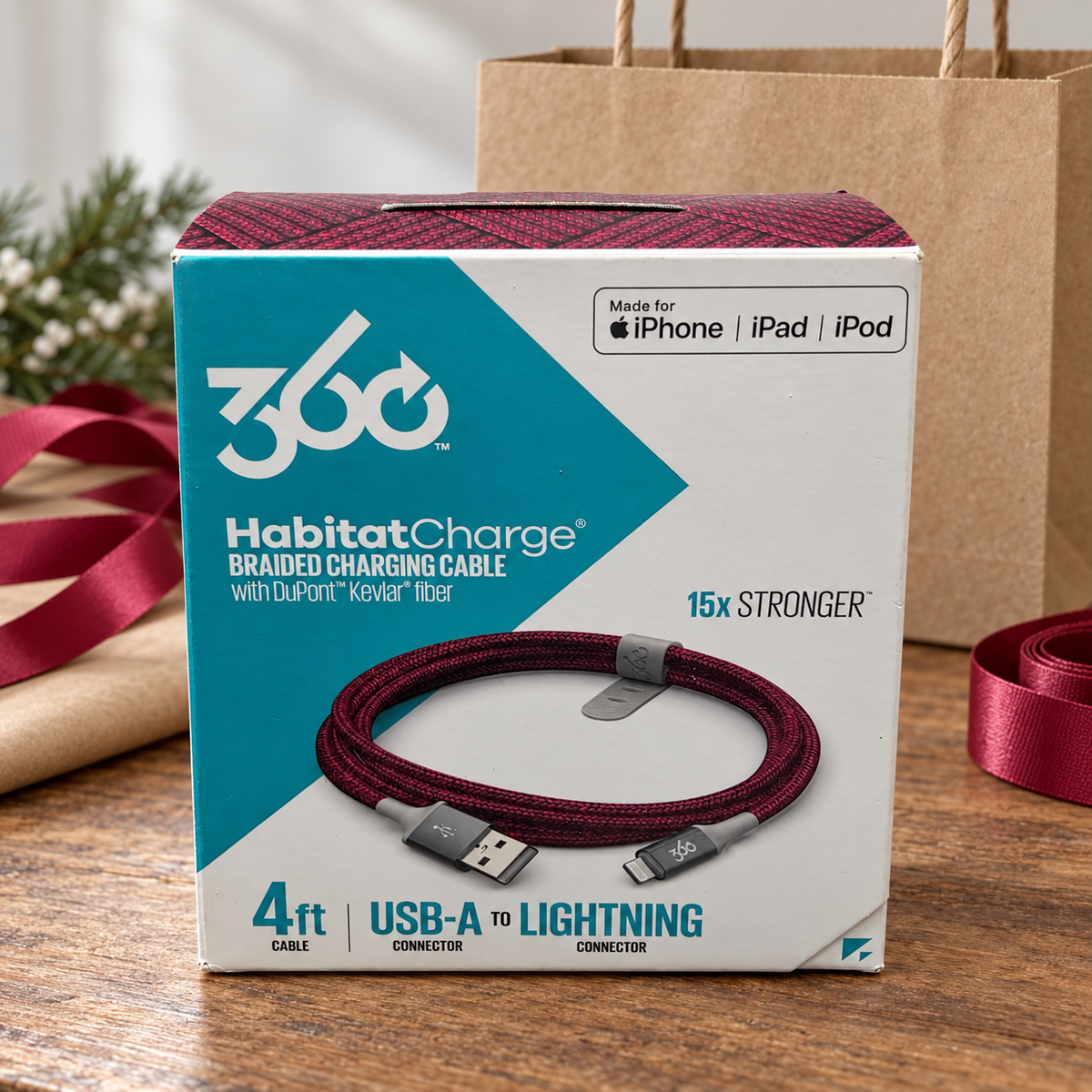 AI-generated lifestyle illustration of one closed HabitatCharge cranberry 4 ft USB-A to Lightning cable box in a gift table setting; background props not included.