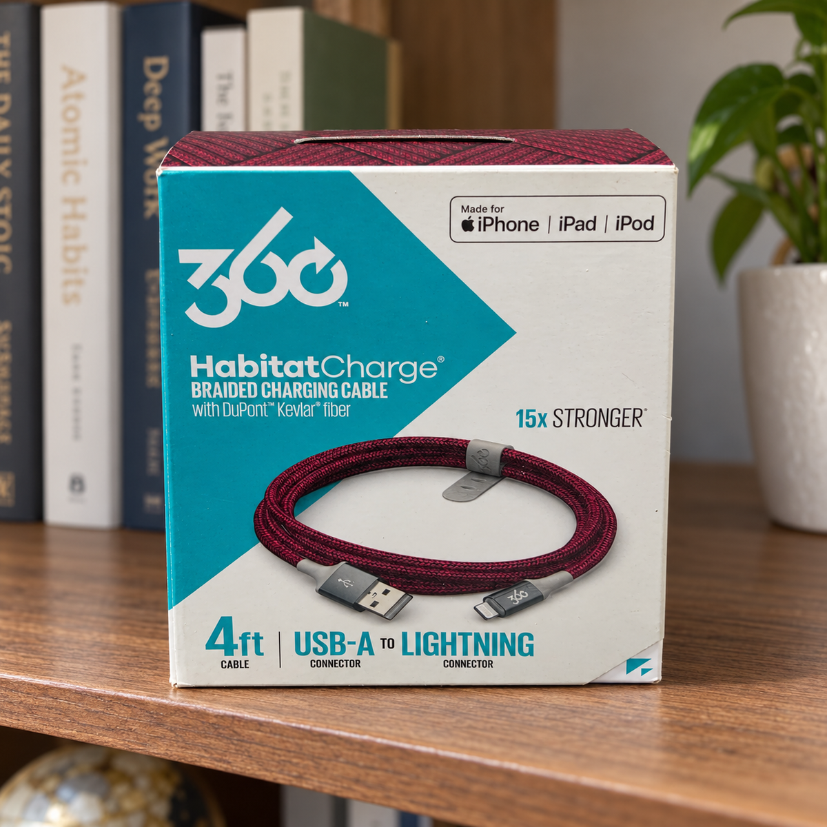 AI-generated lifestyle illustration of one closed HabitatCharge cranberry 4 ft USB-A to Lightning cable box in a shelf setting; background props not included.