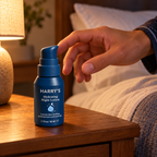 Adult reaching for Harry's Hydrating Night Lotion on a bedside table
