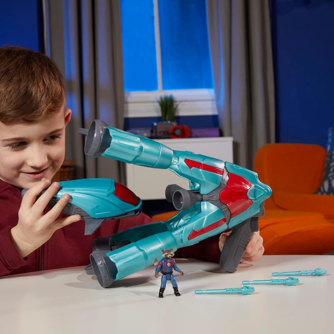 Child holding the removable space pod beside the Galactic 2-in-1 Spaceship, Rocket figure and three projectiles.