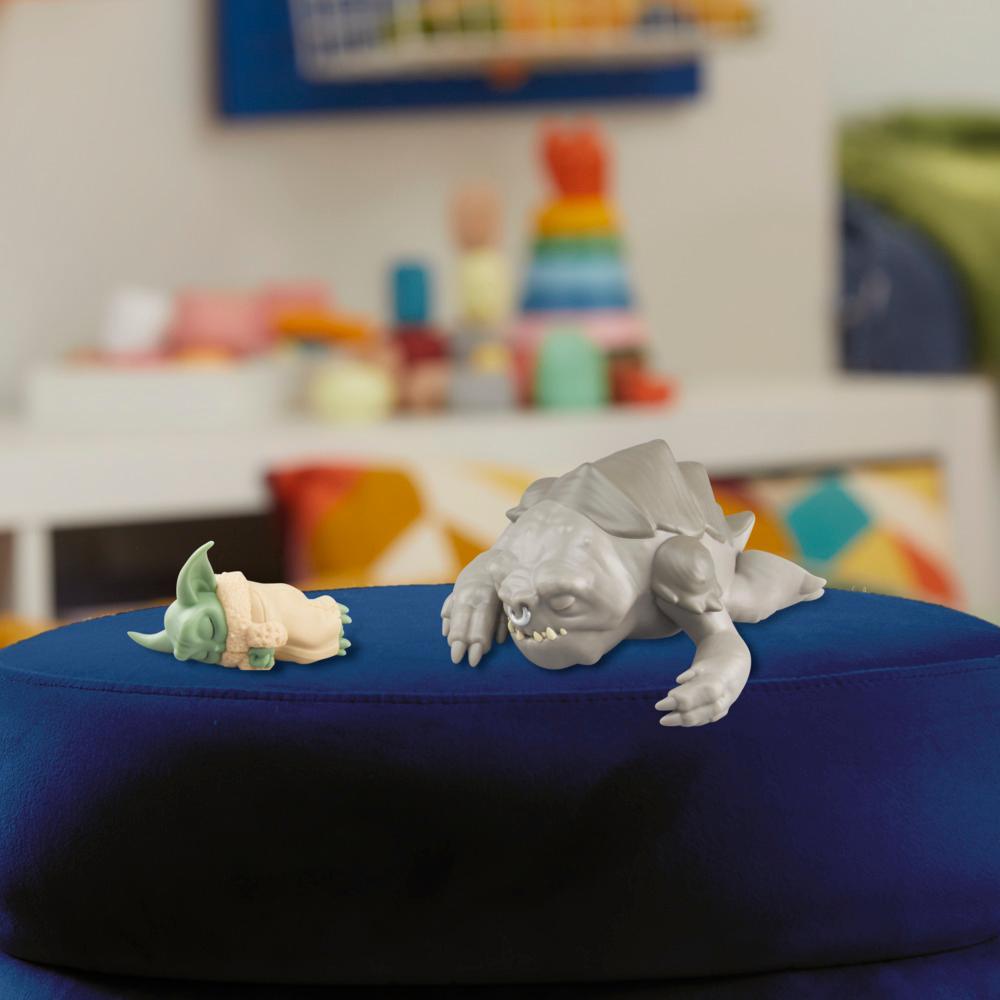 Grogu and Rancor figures displayed separately on a blue ottoman, manufacturer view showing their relative sizes