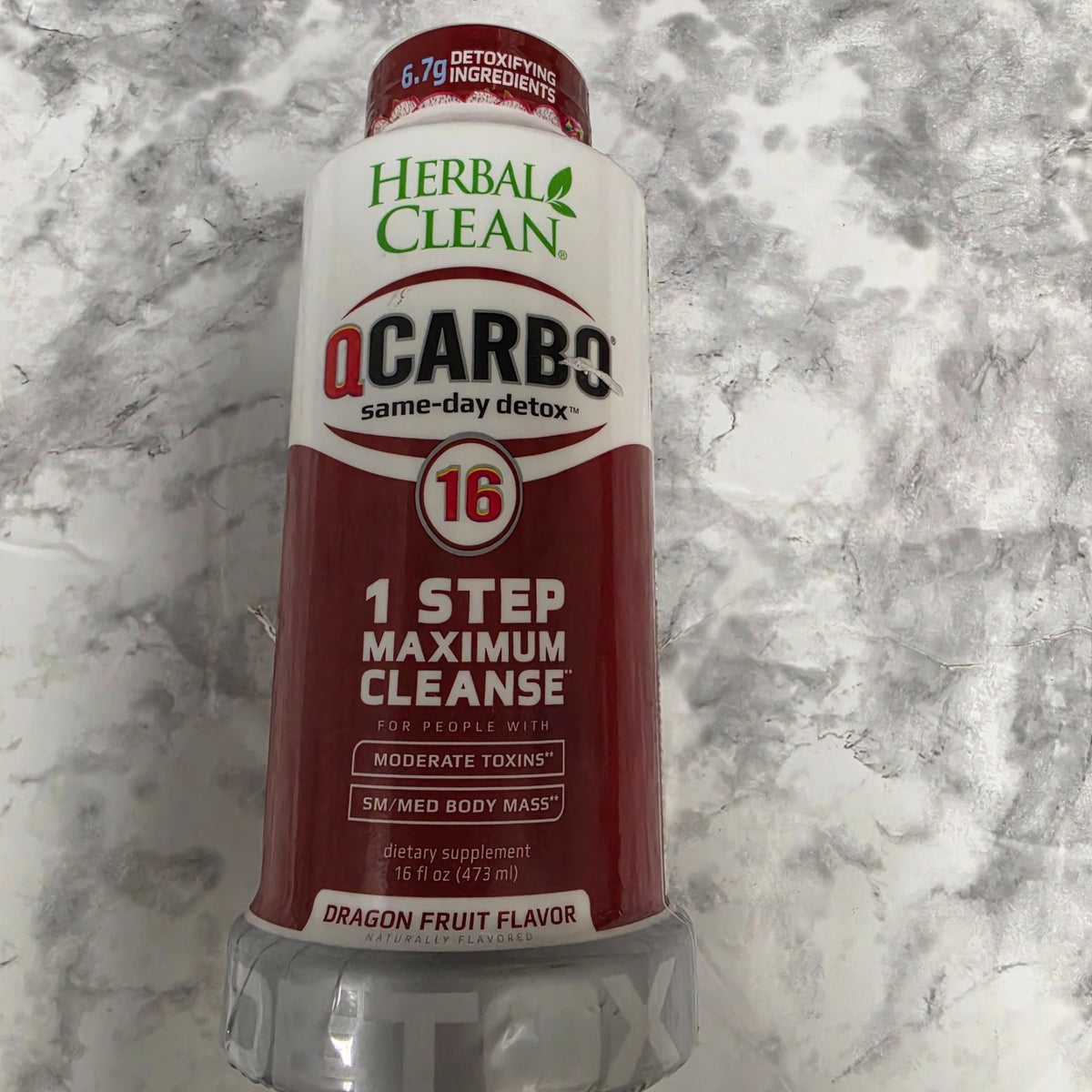 Herbal Clean QCarbo16 Dragon Fruit 16 fl oz bottle with red label on a marble background