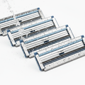 Premium steel razor blades glistening under focused water spray macro shot