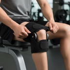 Person on gym bench securing wrap-around compression straps of black hinged knee brace