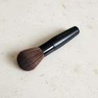 Mary Kay Mineral Foundation Brush lying on a light stone surface