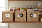 Whitmor silver label clips attached to woven storage baskets on organized pantry shelf