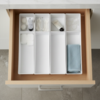 AI-generated illustrative bathroom-vanity drawer context showing four organizers; not the actual stocked item.