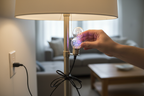 Hand screwing a dual-head specialty LED disco bulb into a standard floor lamp socket