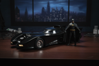 AMT 1/25 scale 1989 Batman Batmobile model kit fully assembled on dark wood hobby desk with resin Batman figure standing beside it and dramatic Gotham moody lighting