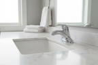 Polished chrome single-handle centerset bathroom faucet installed on pristine white undermount sink