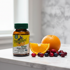 MegaFood Women's 40+ One Daily amber glass bottle beside fresh organic oranges cranberries and blueberries on white marble – More4less Outlet