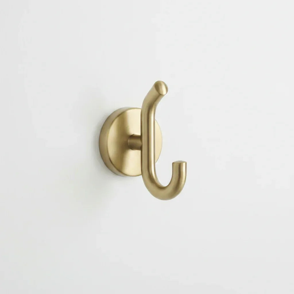 Professional hardware install shot showing Delta Trinsic Champagne Bronze finish robe hook mounted on bathroom wall