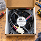 GE WR60X10358 condenser fan in its open box on a repair workbench