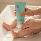 Parent applying JAFRA Tender Moments Baby Massage Cream to baby on white changing mat – More4less Outlet