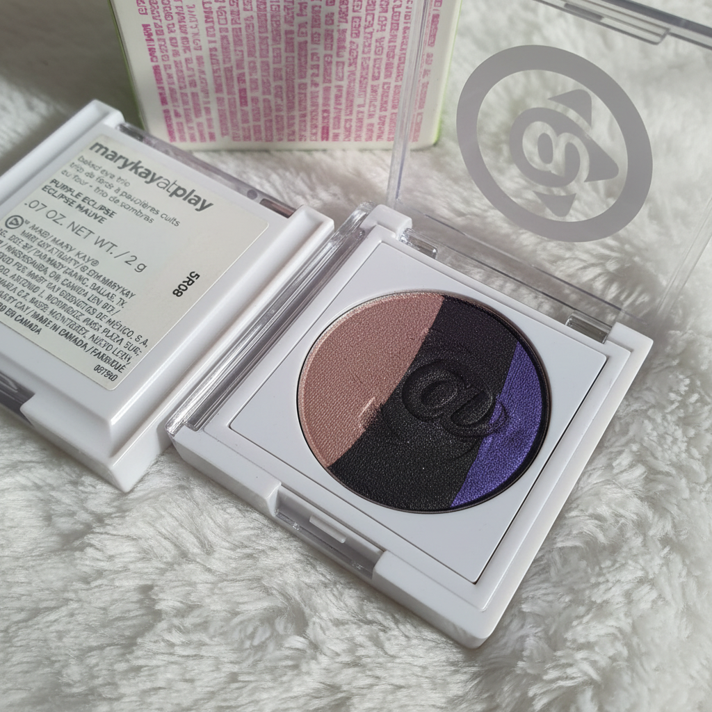 Mary Kay At Play Baked Eye Trio close-up showing baked eyeshadow shimmer in purple, blue-black, and champagne taupe