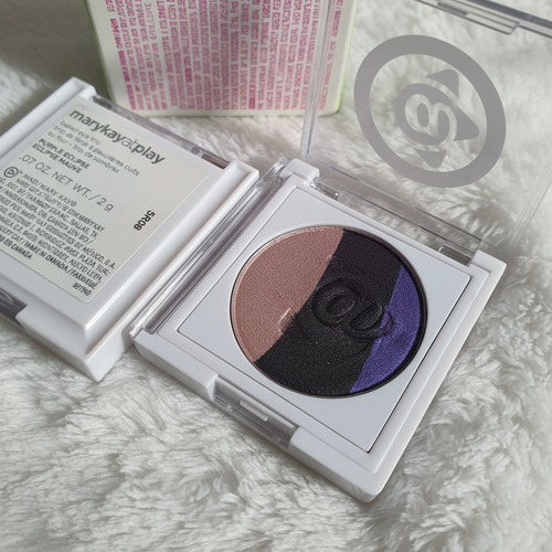 Mary Kay At Play Baked Eye Trio close-up showing baked eyeshadow shimmer in purple, blue-black, and champagne taupe