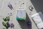 Thymes White Wisteria Candle spring flatlay on grey linen with wisteria petals eucalyptus and crystal bottle - More4less Outlet