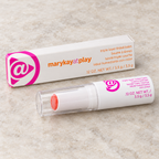 Mary Kay at Play Triple Layer Tinted Balm tube and box on a pale stone surface