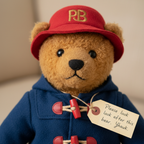 Eden Toys Paddington Bear plush close-up brown curly fur black button eyes blue duffle coat red toggle buttons red PB hat gold embroidery luggage tag collectible detail - More4less Outlet