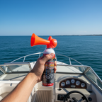 Falcon Safety signal horn orange trumpet air horn held up on motorboat deck on open water, sunny day boating safety lifestyle