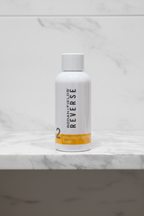 Rodan + Fields REVERSE Intensive Brightening Toner centered on white marble bathroom shelf with soft studio lighting