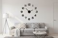 Westclox 20-inch floating wall clock installed on white living room wall above modern grey sofa