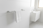 Grohe Essentials polished chrome 2-arm swivel towel bar in minimalist white bathroom with morning sunlight and folded white guest towels