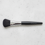 Mary Kay Classic Flat Paddle liquid foundation brush on a light stone surface
