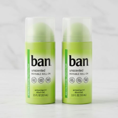 Two lime-green Ban deodorant bottles on marble countertop