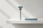 Gillette SkinGuard Sensitive razor handle with four cartridges on bathroom shelf lifestyle