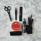 Close up flat lay of Wild Willies 4-piece grooming tools and boar bristle brush on white marble