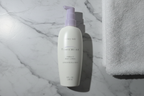 Mary Kay TimeWise Visibly Fit Body Lotion bottle in flat lay on white marble with soft white towel