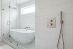 Bright modern bathtub and shower setup displaying precise control valve escutcheon plate integration