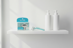 Minimalist white bathroom shelf with Gillette Venus Deluxe Smooth Sensitive refill box, Venus razor handle, and personal care bottles in soft natural light