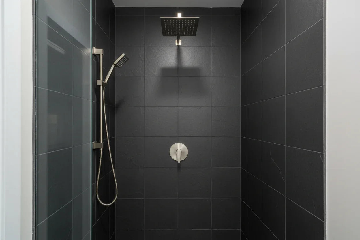 Minimalist professional shower stall featuring Pfister brushed nickel valve trim against dark slate tile