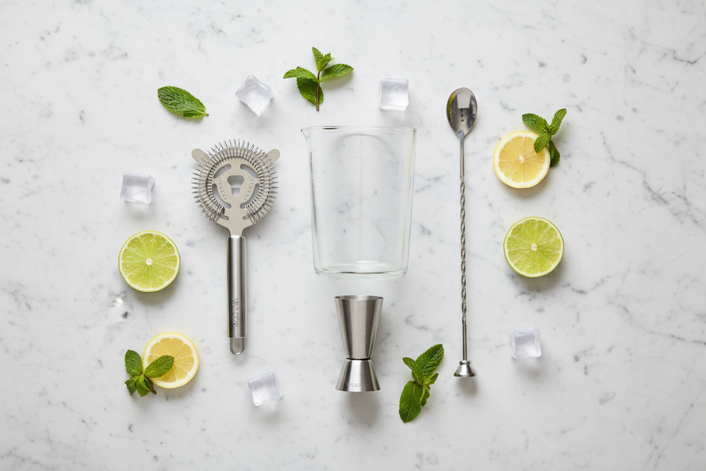 Houdini 4-Piece Cocktail Tool Set flat lay on white marble with citrus and ice styling - More4less Outlet