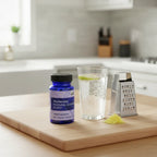 Motherlove Morning Sickness Blend bottle on light-wood kitchen island with sparkling water and ginger grater