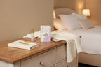 Soft-lit bedroom dresser with Winged Wellness Sleepyhead sleep gummies and wellness products