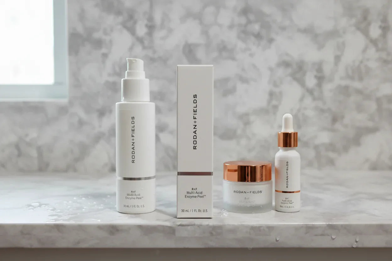 Morning skincare setup with Rodan + Fields peel box and white cosmetic bottles on neutral stone surface
