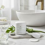 Spa-like setting featuring botanical skincare treatments and fresh water elements with white jar and green plant accents on marble